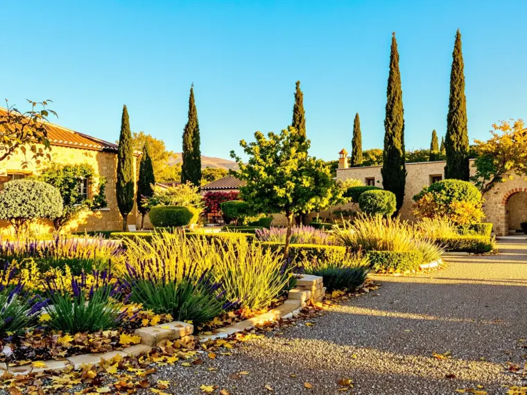 Jardín otoñal en Toledo con lavanda, romero y hojas caídas bajo la luz dorada de octubre
