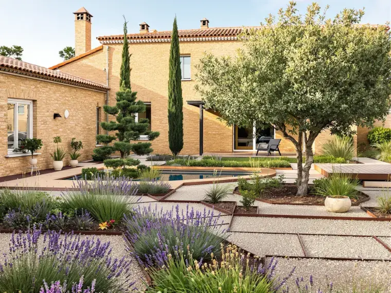 Jardín de diseño recién construido con caminos de grava, corten, olivo y lámina de agua